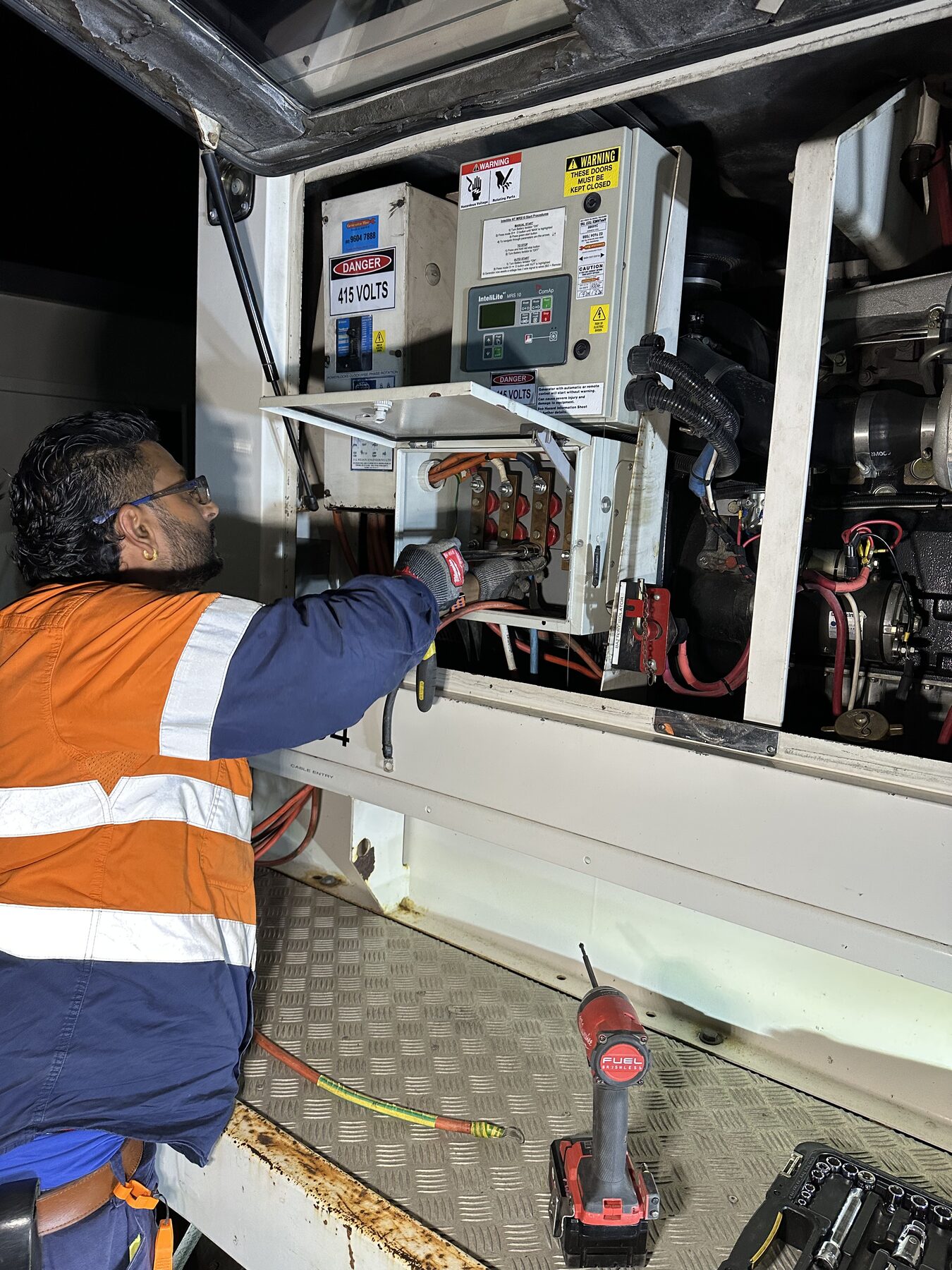 Mega Power Services electrician terminating 415V three-phase connections on a generator changeover during a night emergency call-out in Sydney