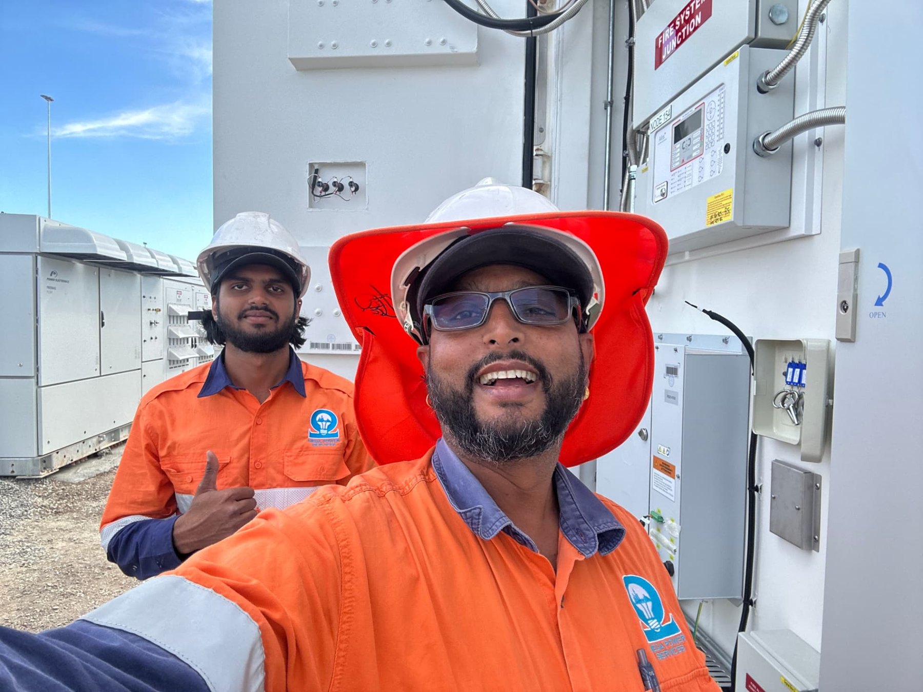 Ajen Singh on site in Mega Power Services hi-vis with a crew member at a high-voltage switchroom